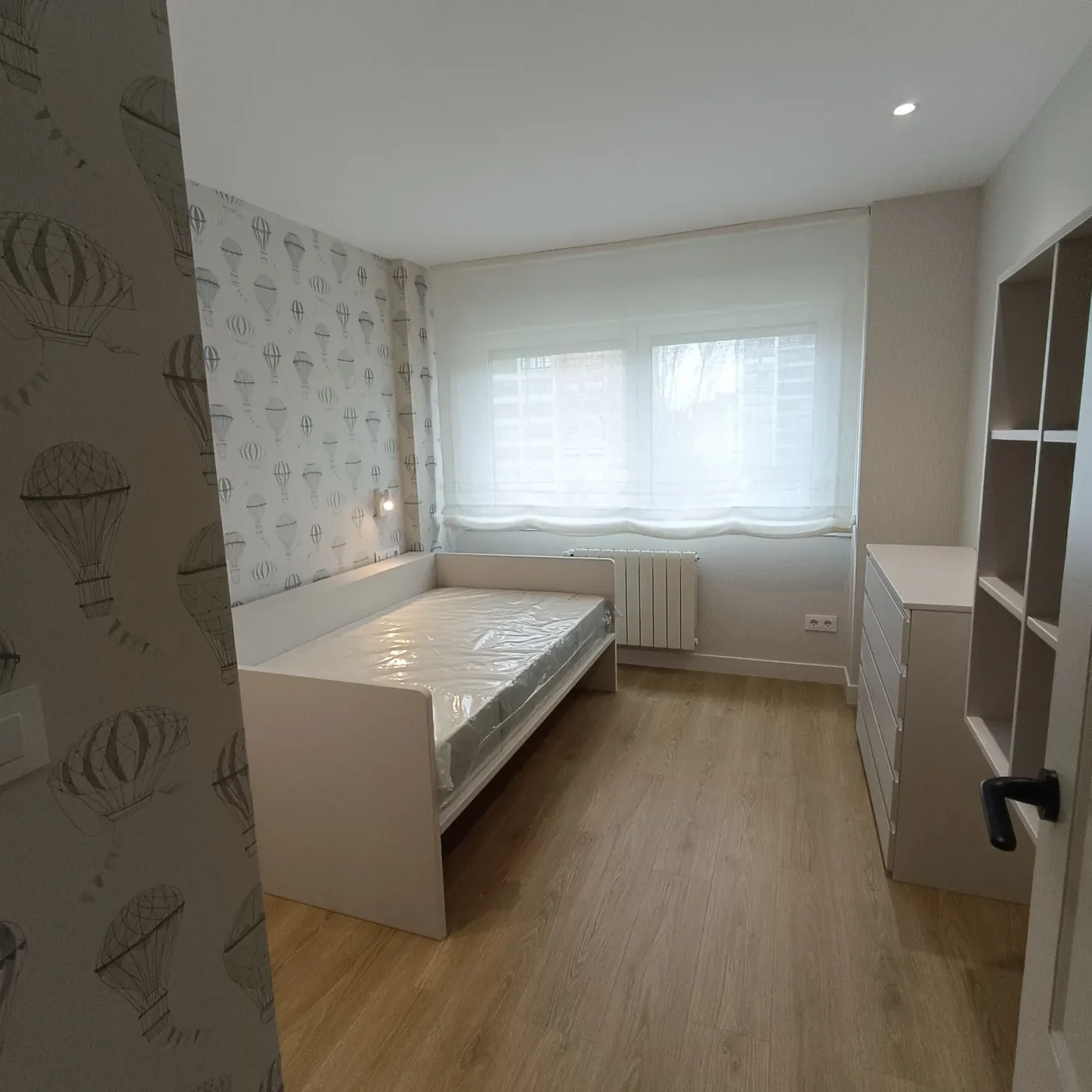 Dormitorio infantil con cama nido y mobiliario lacado en blanco