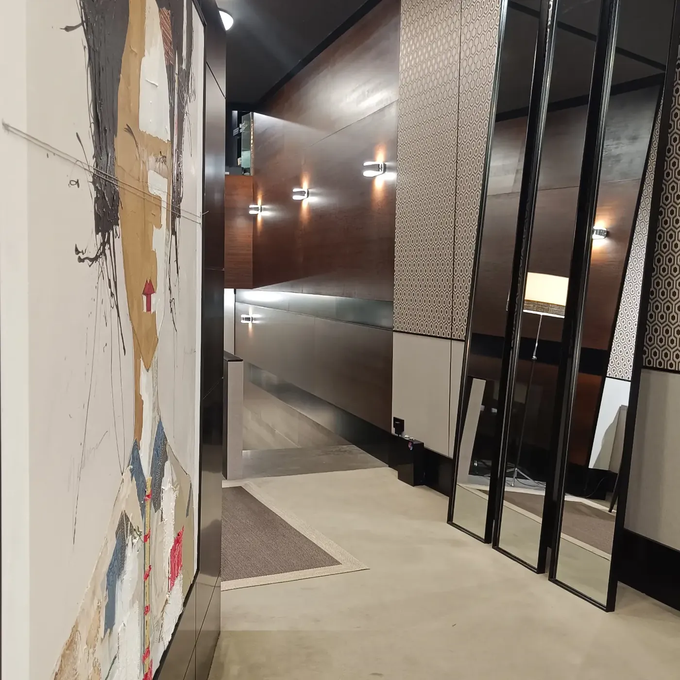 Acceso al local con obra de gran formato y espejos de pie