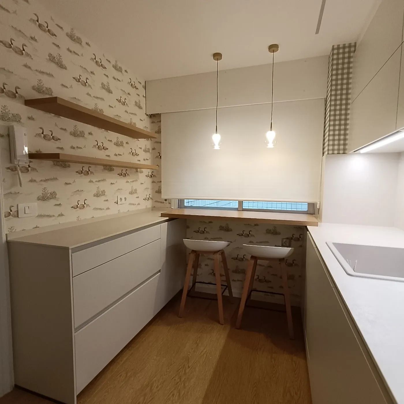 La cocina desde la entrada, con frentes claros y luz bajo mueble