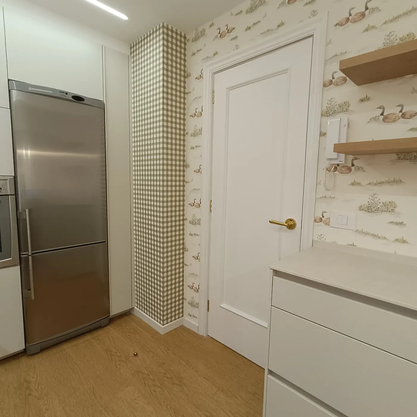 Paso hacia la cocina con la columna del frigorífico y el papel continuo