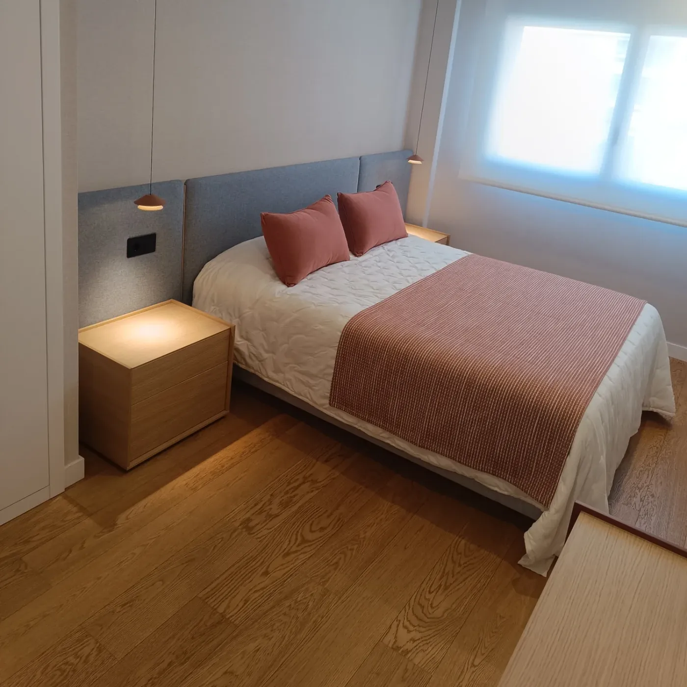 El dormitorio desde la puerta, con la cama vestida en teja y blanco