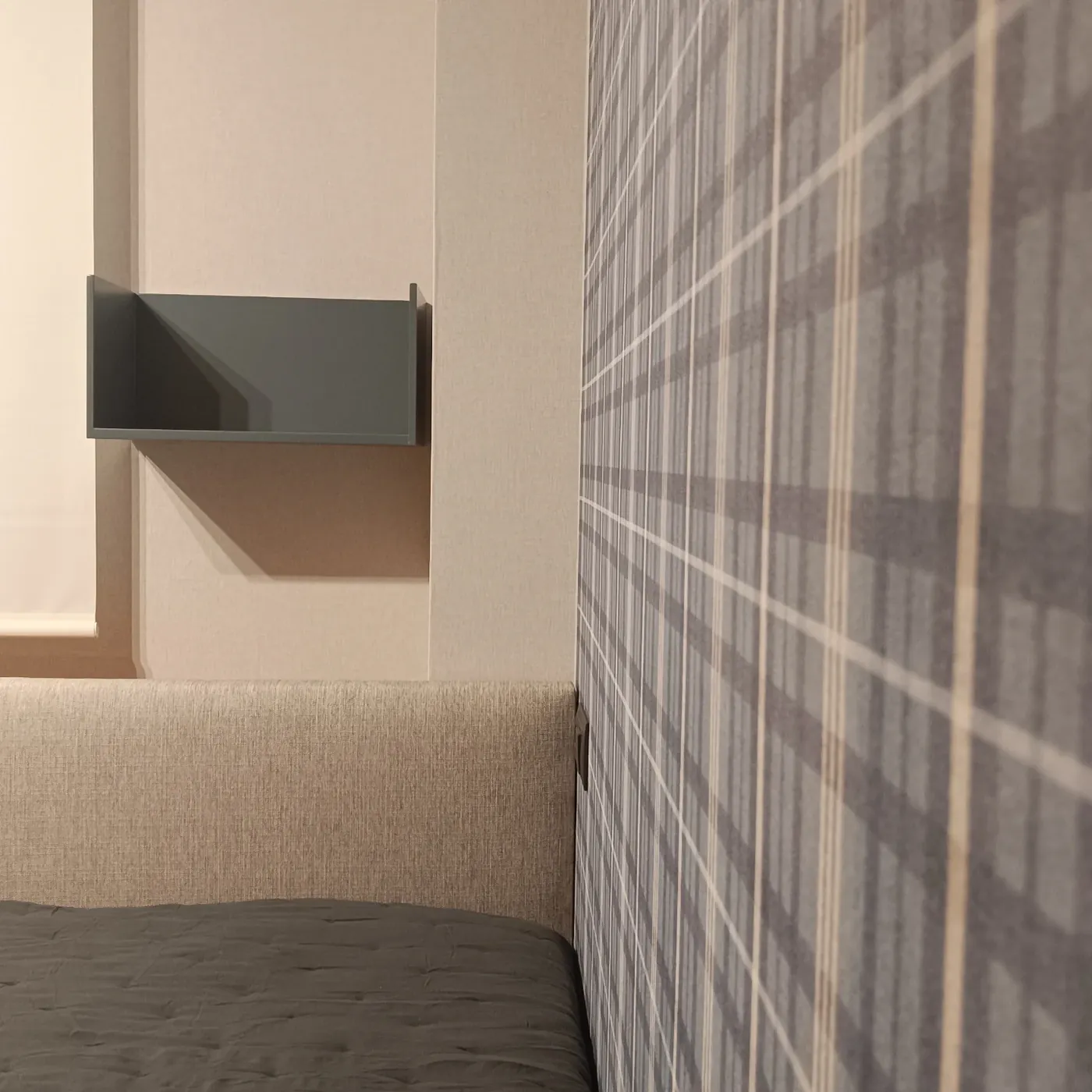 Detalle del cabecero tapizado y la cortina de la habitación juvenil