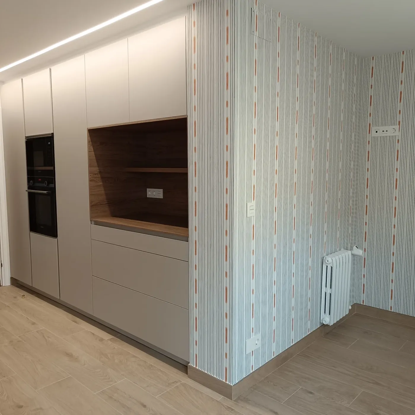 Cocina con frente lacado, hueco revestido en madera y papel de rayas finas