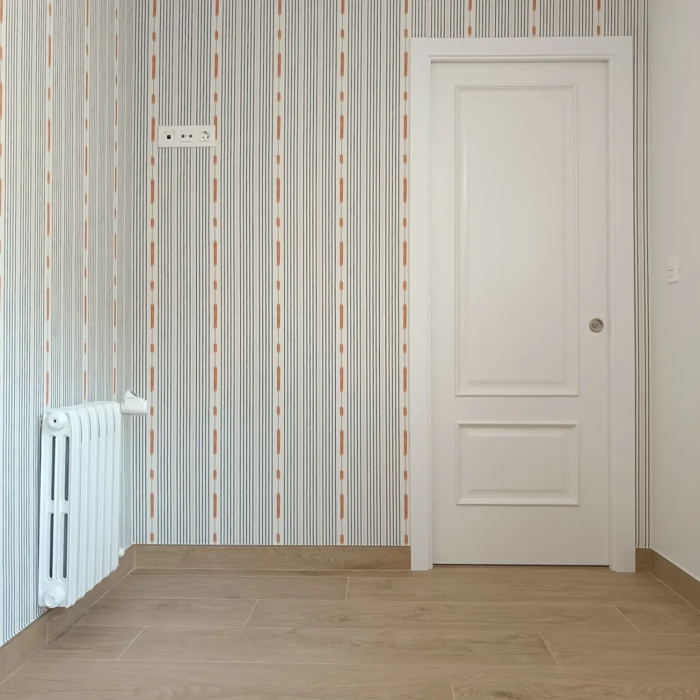Papel de rayas y puerta blanca en el distribuidor