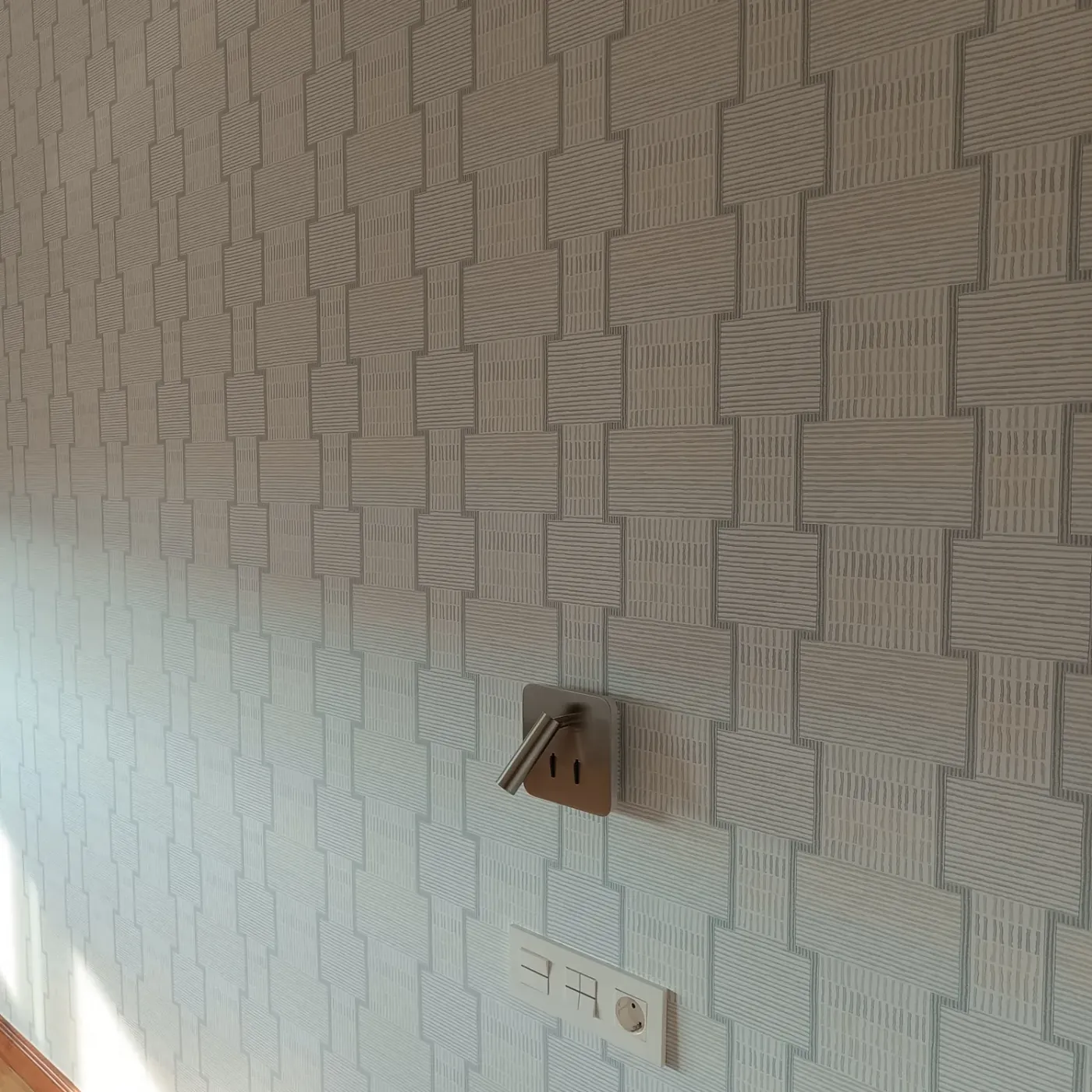Papel pintado geométrico en verde suave sobre la pared