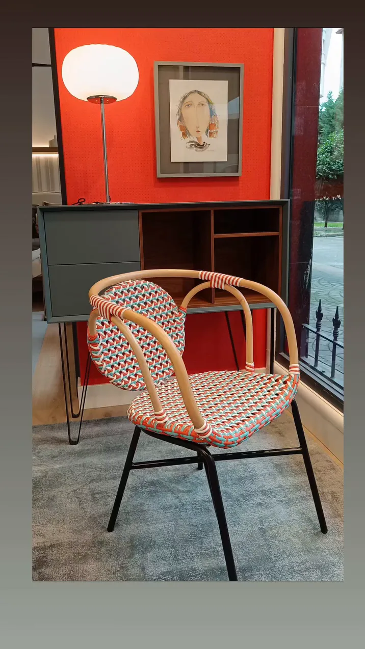 Rincón con papel pintado rojo, silla de rattan y lámpara de pie de globo